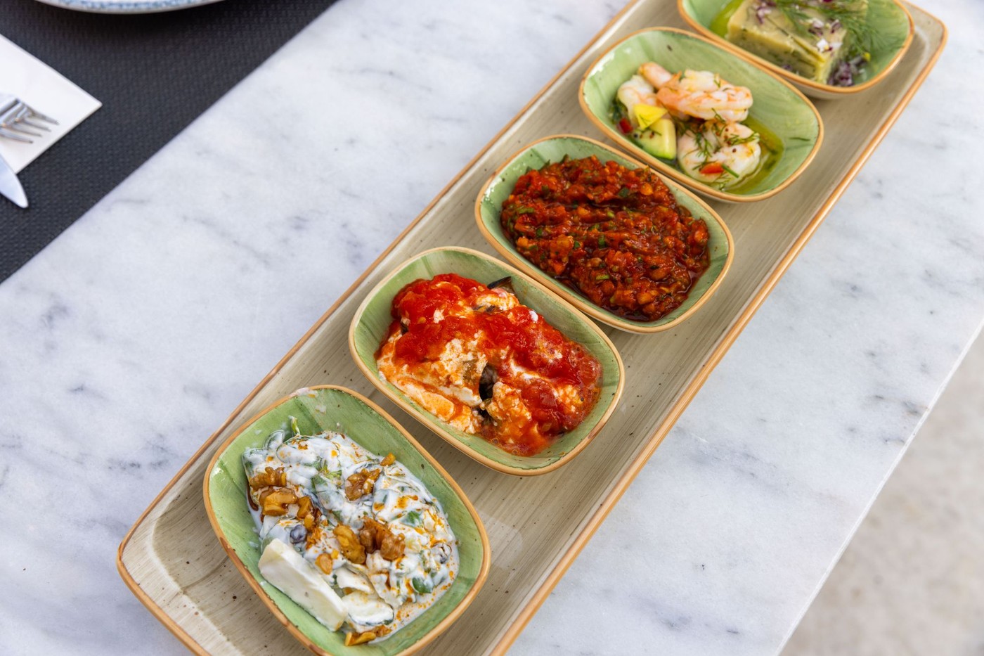A mezze spread of Mediterranean dishes on a marble table, used here as a representative image