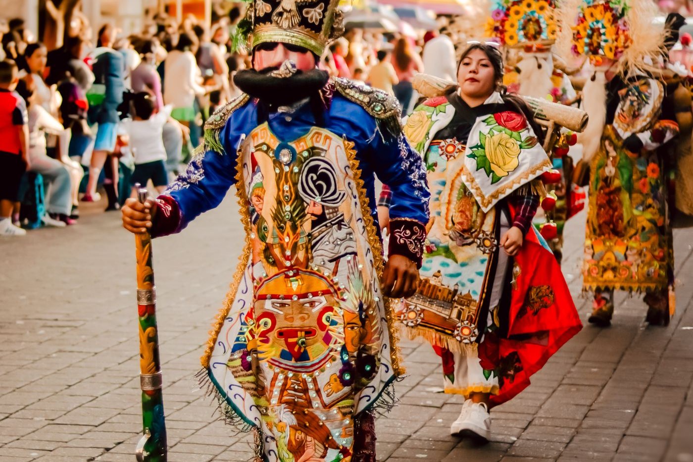 Performers in colorful traditional dress march in a vibrant cultural parade