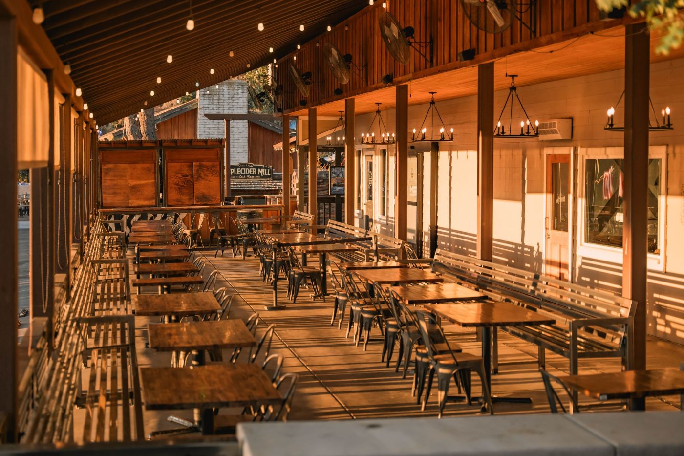 An outdoor restaurant patio with tables and chairs set for dining